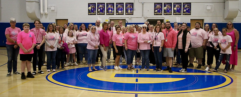 middle school teachers presenting gift from pink zone benefit