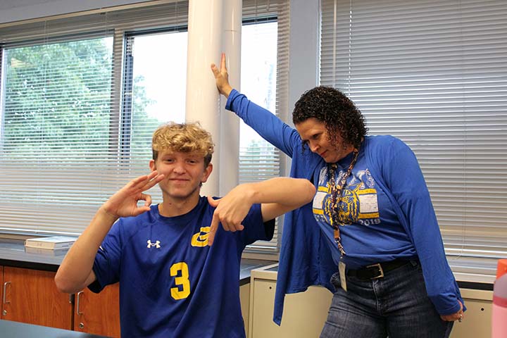 student showing 67 while teacher looks on