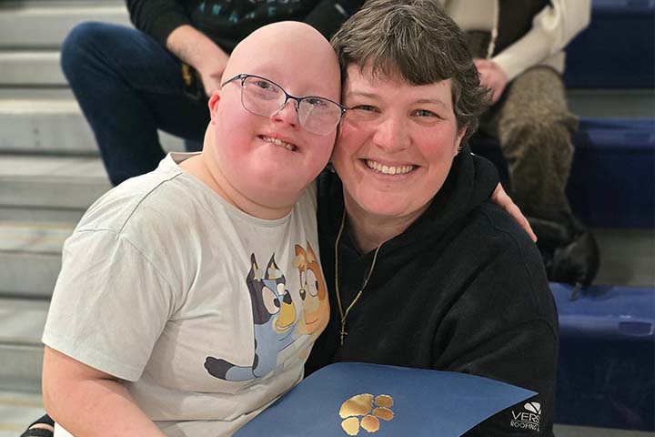 student with adult holding a positivity award