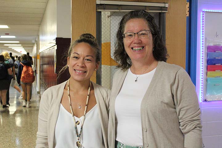 teachers posing in front of classroom door