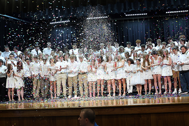 class of 2024 students on stage at moving up day with confetti poppers