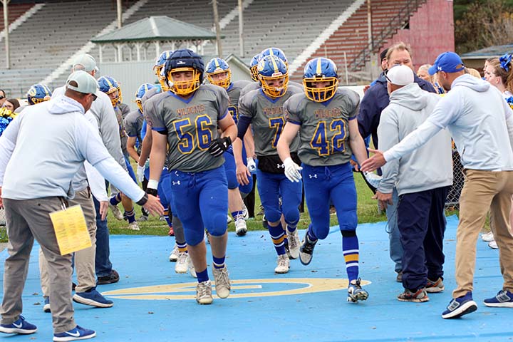 football coaches greeting their team members as they enter the field before a game