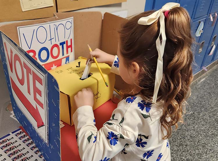elementary student casting a vote