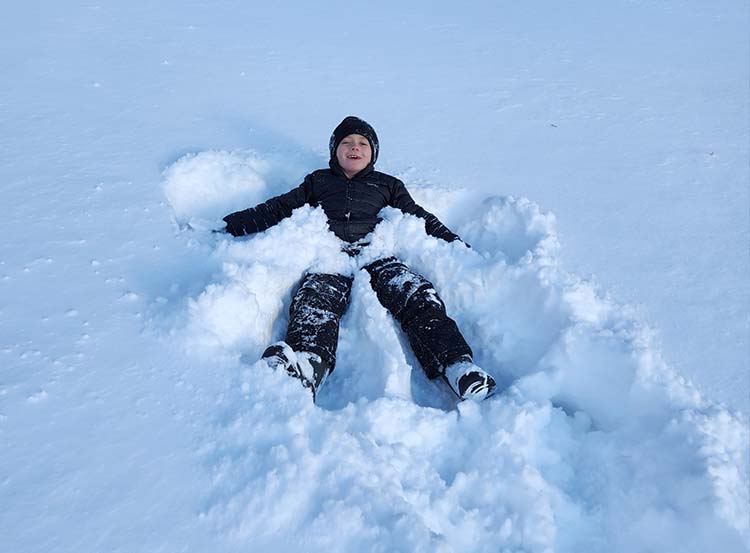 elementary student making snow angel