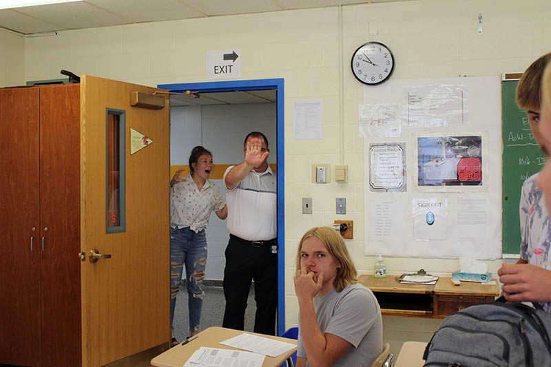 student scaring teacher in doorway